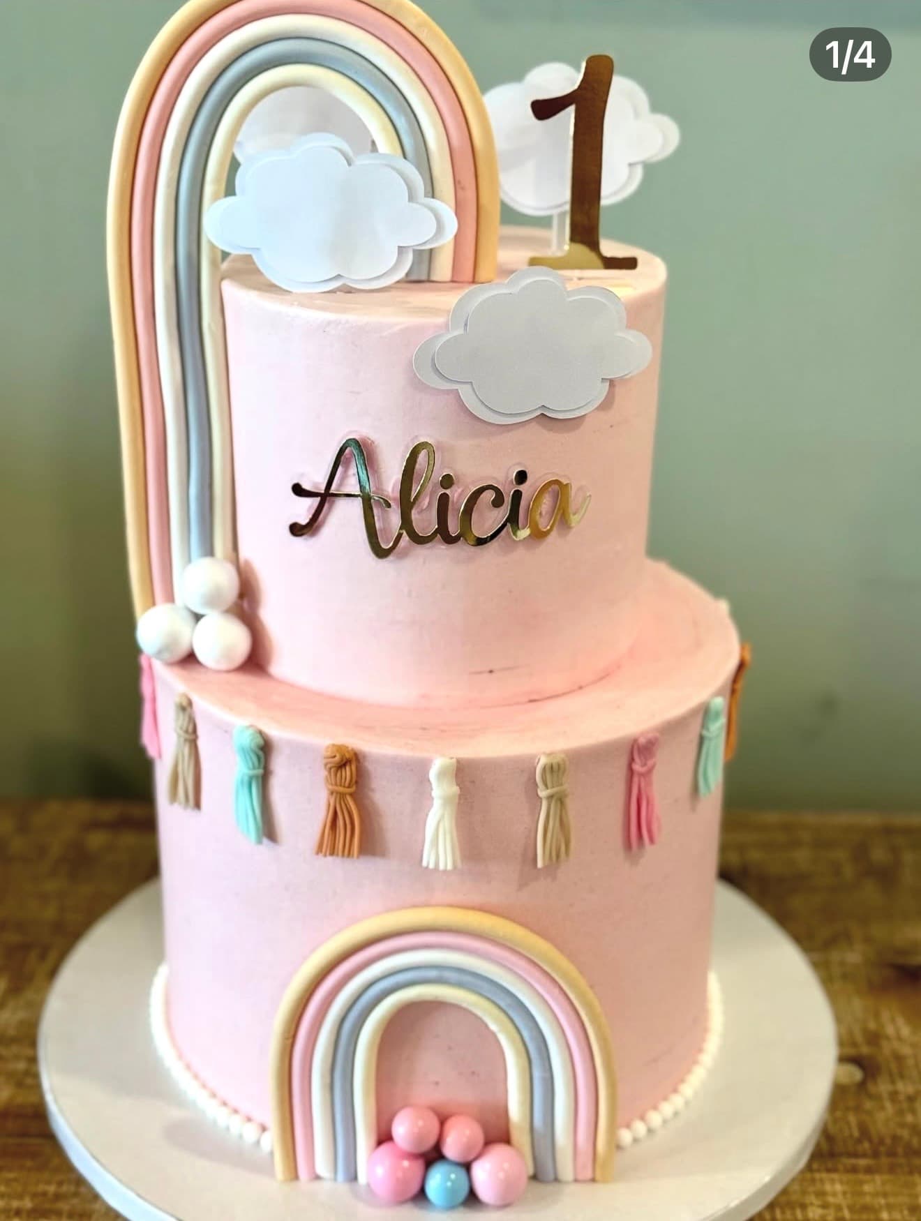 Arco-Íris Pastel — Dois andares rosa com arco-íris em tons pastel, nuvens, borlas decorativas e bolas de açúcar.