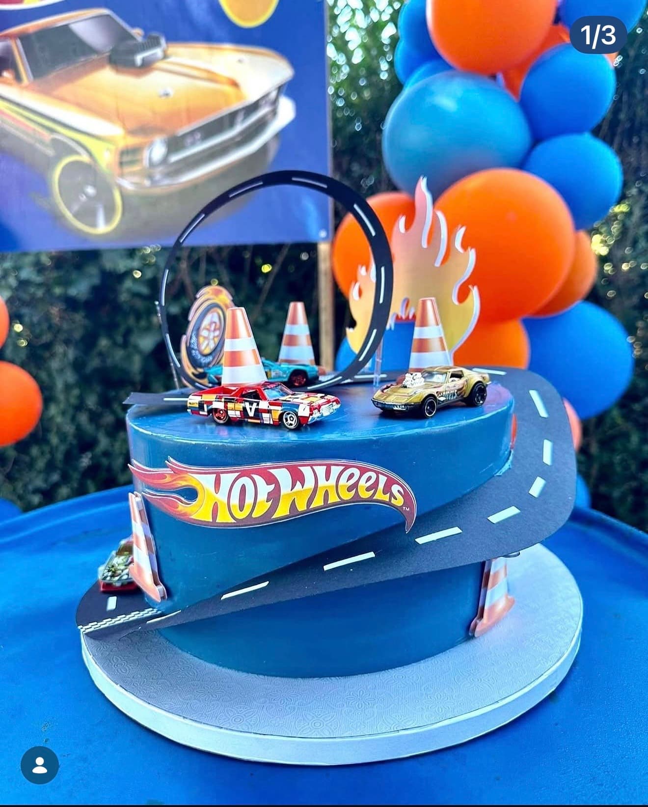 Hot Wheels — Pista em espiral com carrinhos Hot Wheels, chamas, cones e loop em tons azul e laranja.